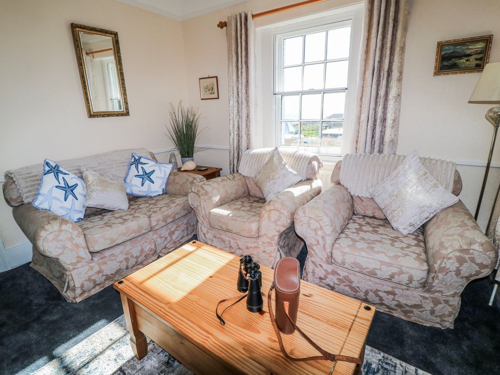 A living room with sofas and a coffee table at Old Higher Lighthouse Stopes Cottage Portland Bill