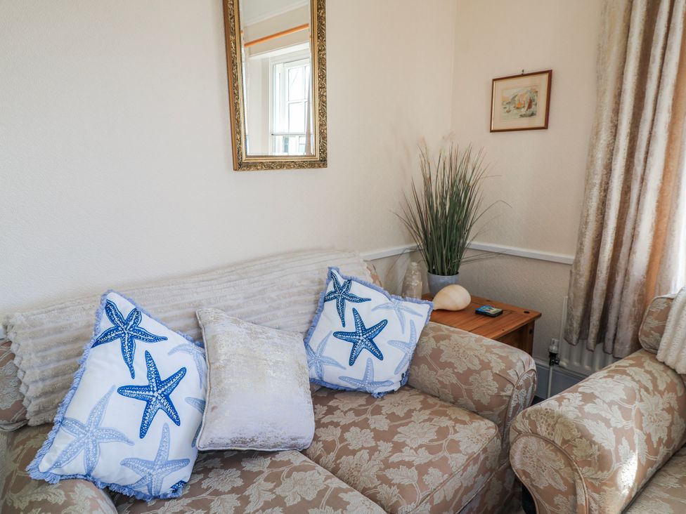 A living room with a sofa and cushions at Old Higher Lighthouse Stopes Cottage in Portland Bill
