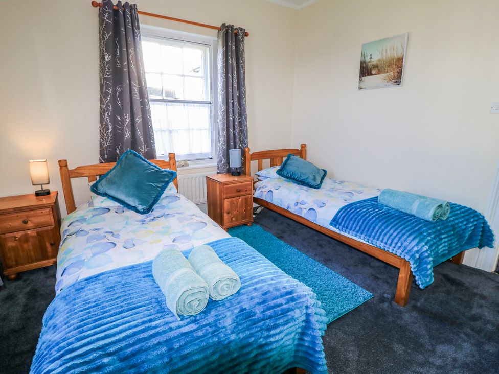 A bedroom with two beds and nightstands at Old Higher Lighthouse Stopes Cottage Portland Bill