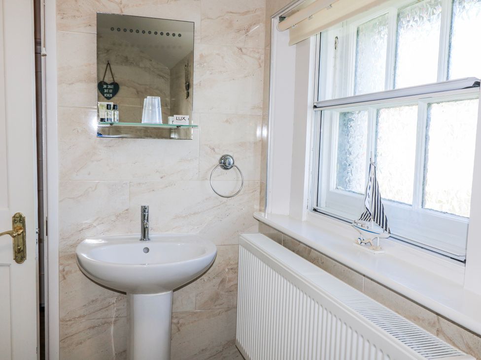 A bathroom with a sink and mirror at Old Higher Lighthouse Stopes Cottage Portland Bill