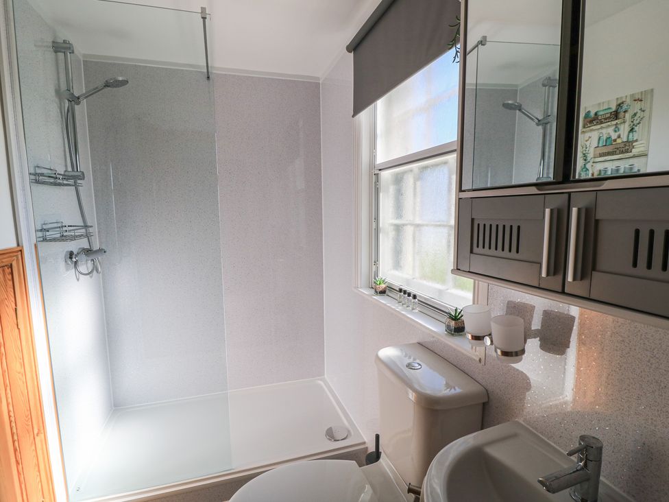 A bathroom with a shower, toilet and sink at Old Higher Lighthouse Branscombe Lodge Portland Bill