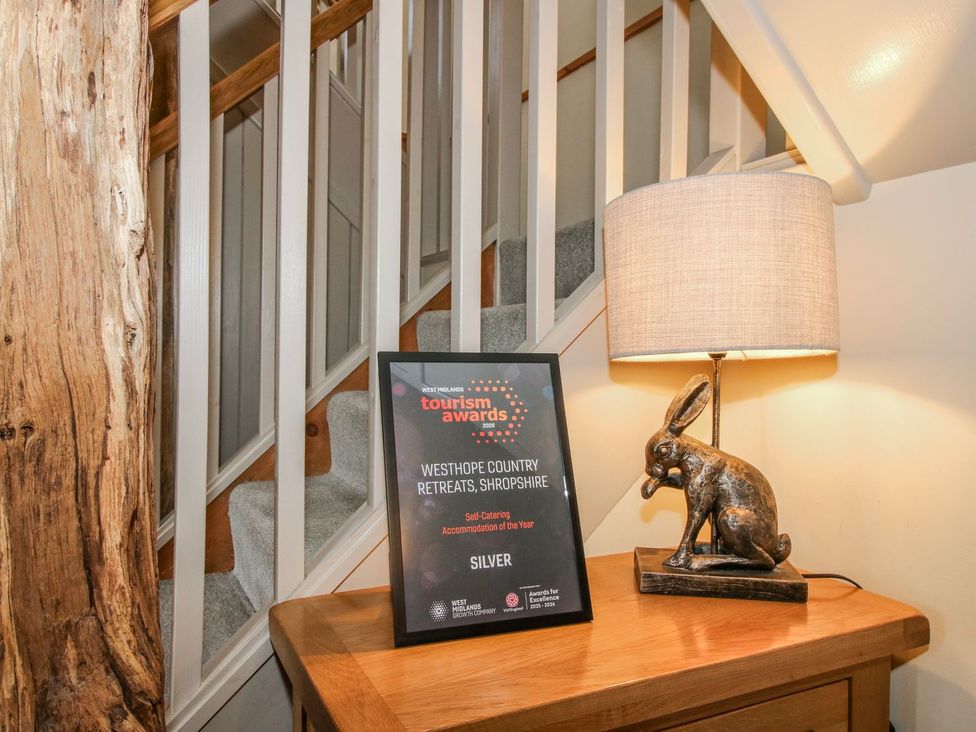 A hallway with a staircase and an award plaque at The Turnip House in Westhope