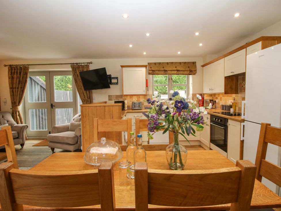 A kitchen with a dining table and flowers at The Turnip House in Westhope