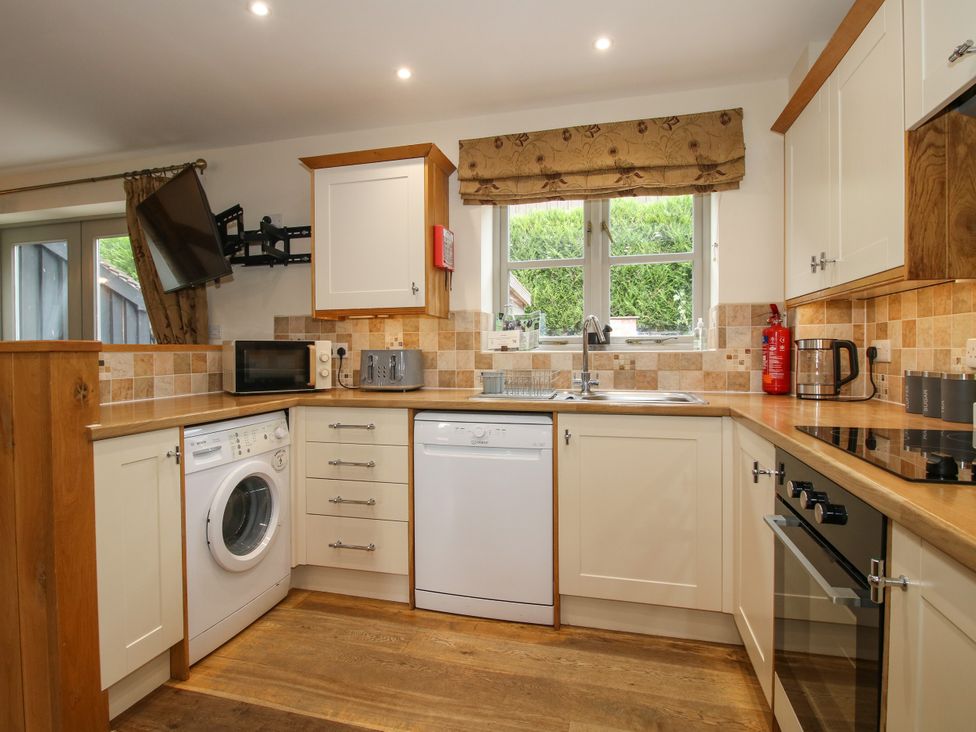 A kitchen with a washing machine and microwave at The Turnip House in Westhope