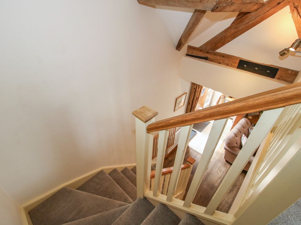 A staircase with a handrail leading to a living area at The Turnip House in Westhope
