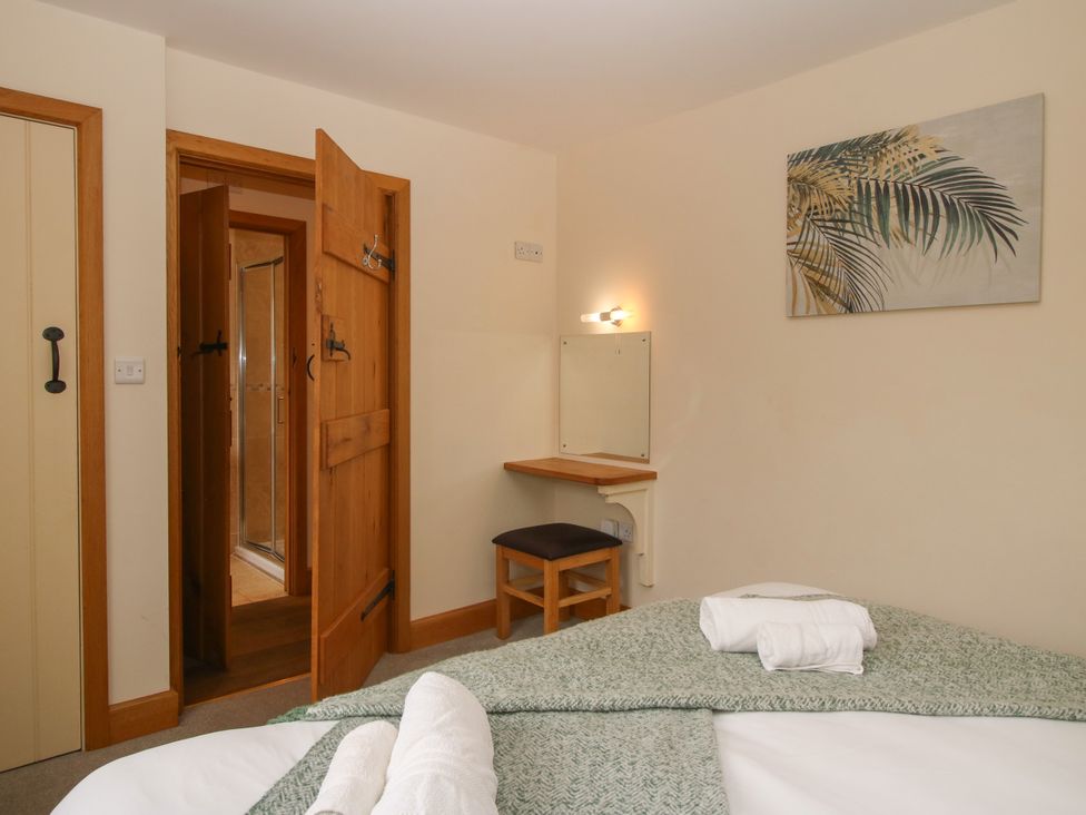 A bedroom with a bed, mirror, and door at The Turnip House in Westhope