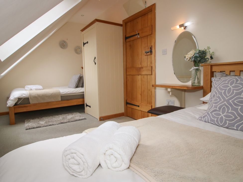 A bedroom with two beds and a mirror at The Turnip House in Westhope