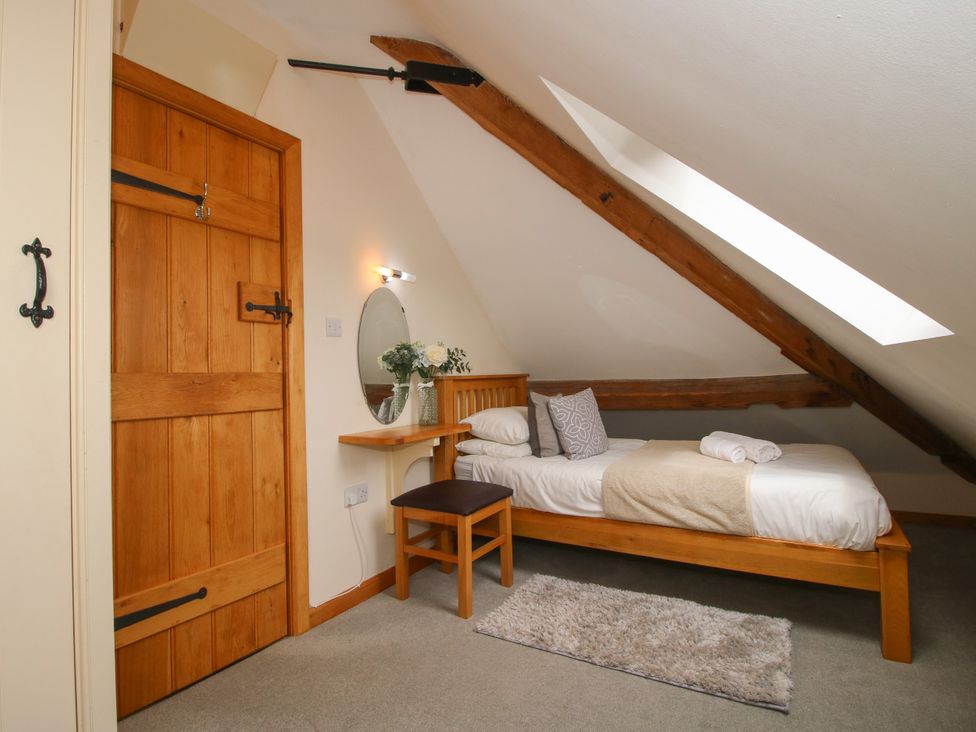 A bedroom with a bed and a mirror at The Turnip House in Westhope