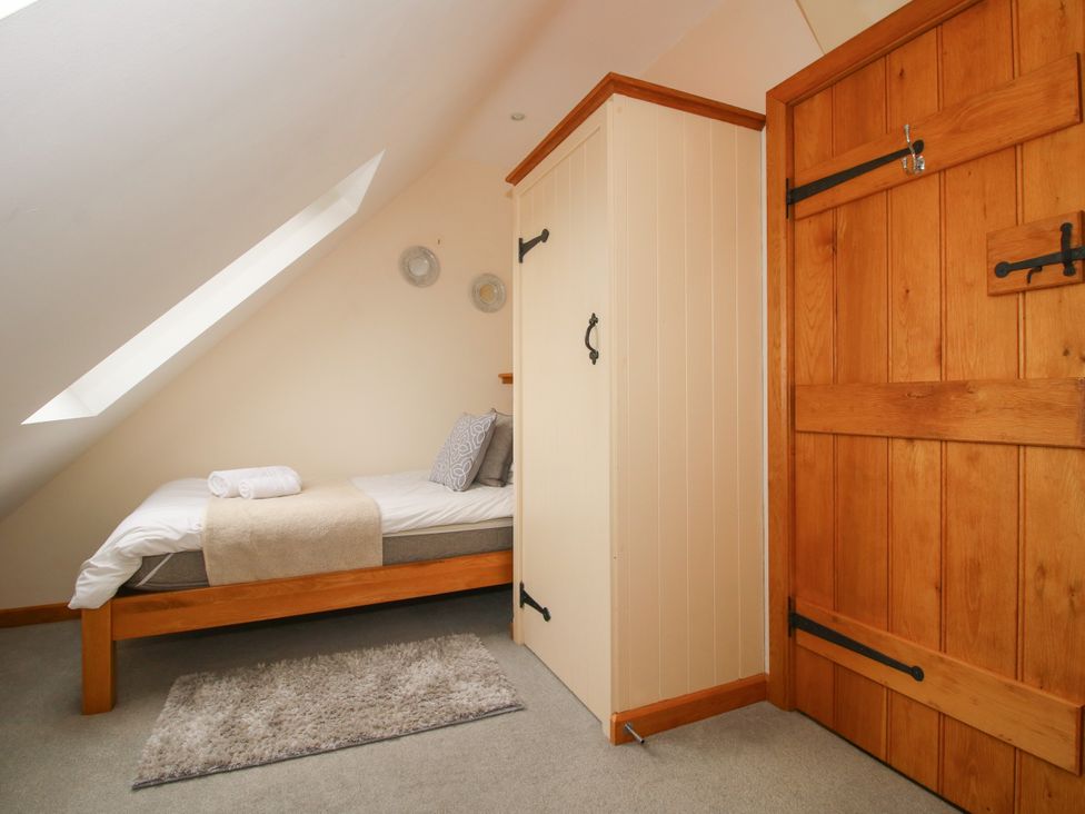 A bedroom with a single bed and a wardrobe at The Turnip House in Westhope