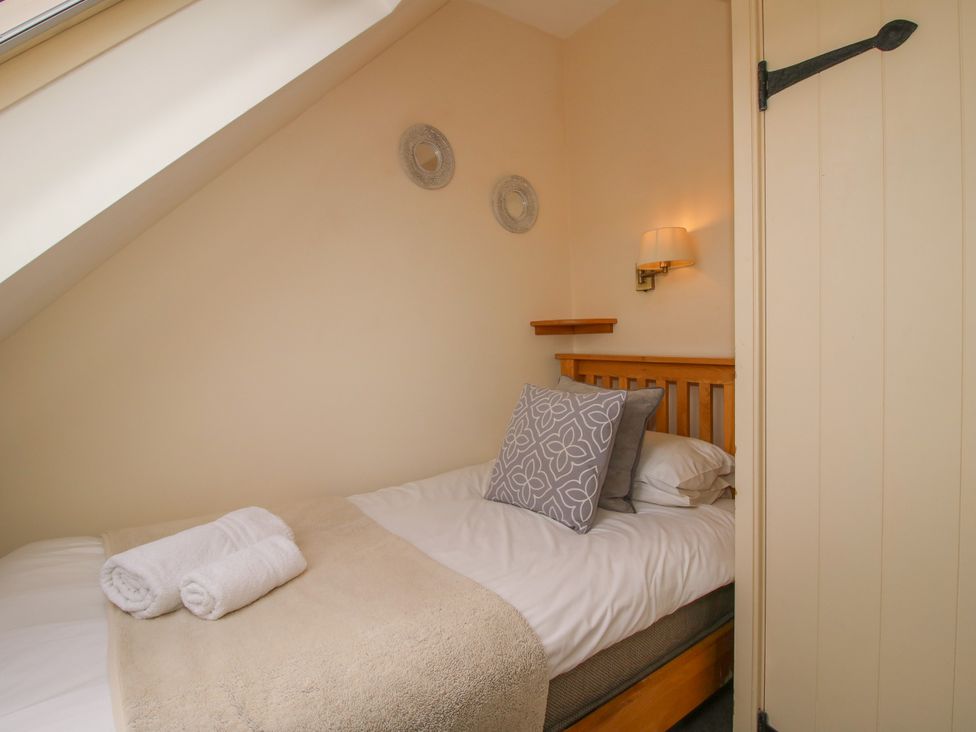 A bedroom with a bed and shelving at The Turnip House in Westhope