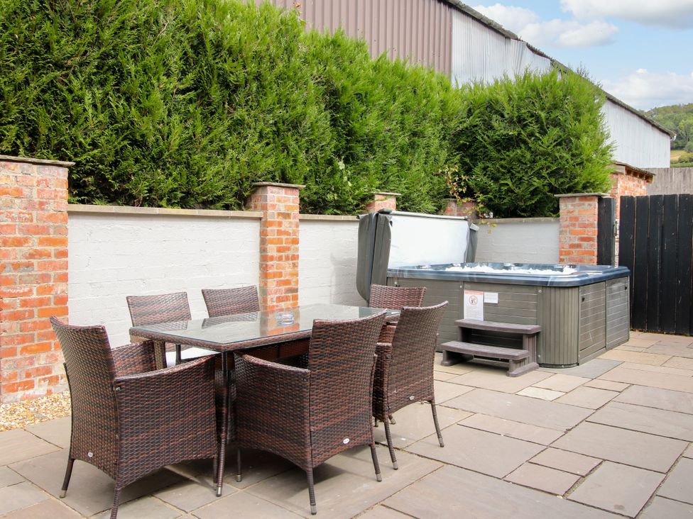 An outdoor space with a hot tub and a dining table at The Turnip House in Westhope