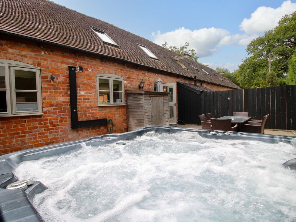 A hot tub with seating area and brick wall at The Turnip House in Westhope
