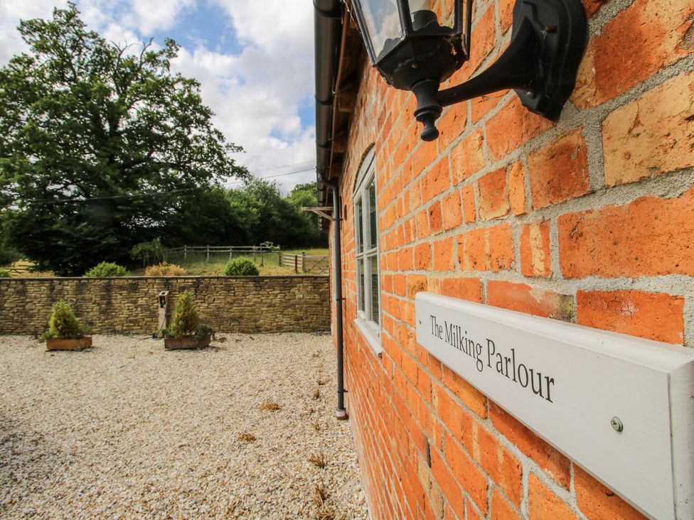 An outdoor area with a brick wall and sign at The Milking Parlour in Westhope