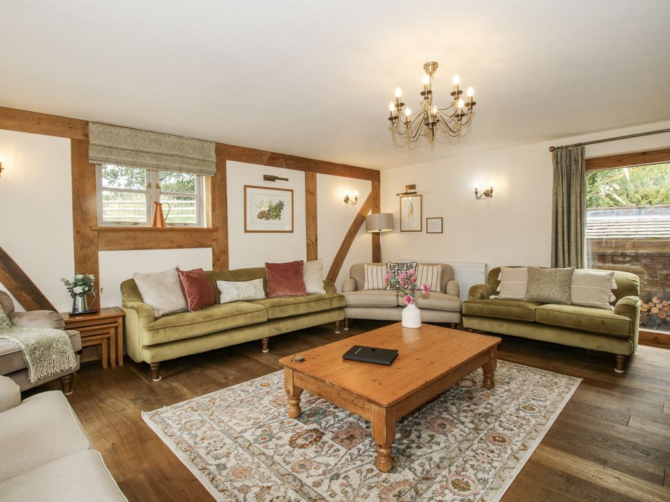 A living room with sofas, a table, and a window at The Milking Parlour in Westhope