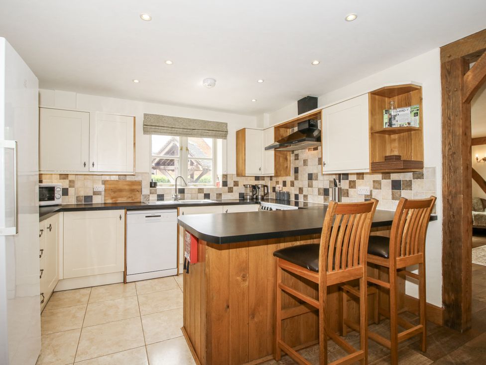 A kitchen with a counter and bar stools at The Milking Parlour in Westhope