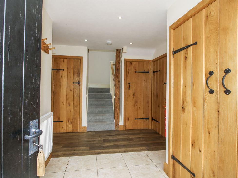 A hallway with wooden doors and staircase at The Milking Parlour in Westhope