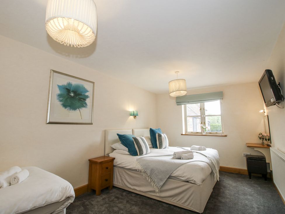 A bedroom with beds and a television at The Milking Parlour in Westhope