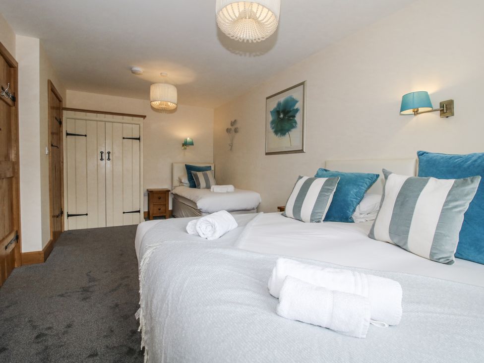 A bedroom with two beds and a wardrobe at The Milking Parlour in Westhope