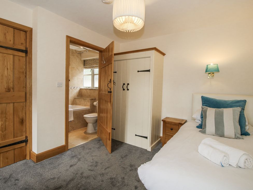 A bedroom with a bed and wardrobe at The Milking Parlour in Westhope