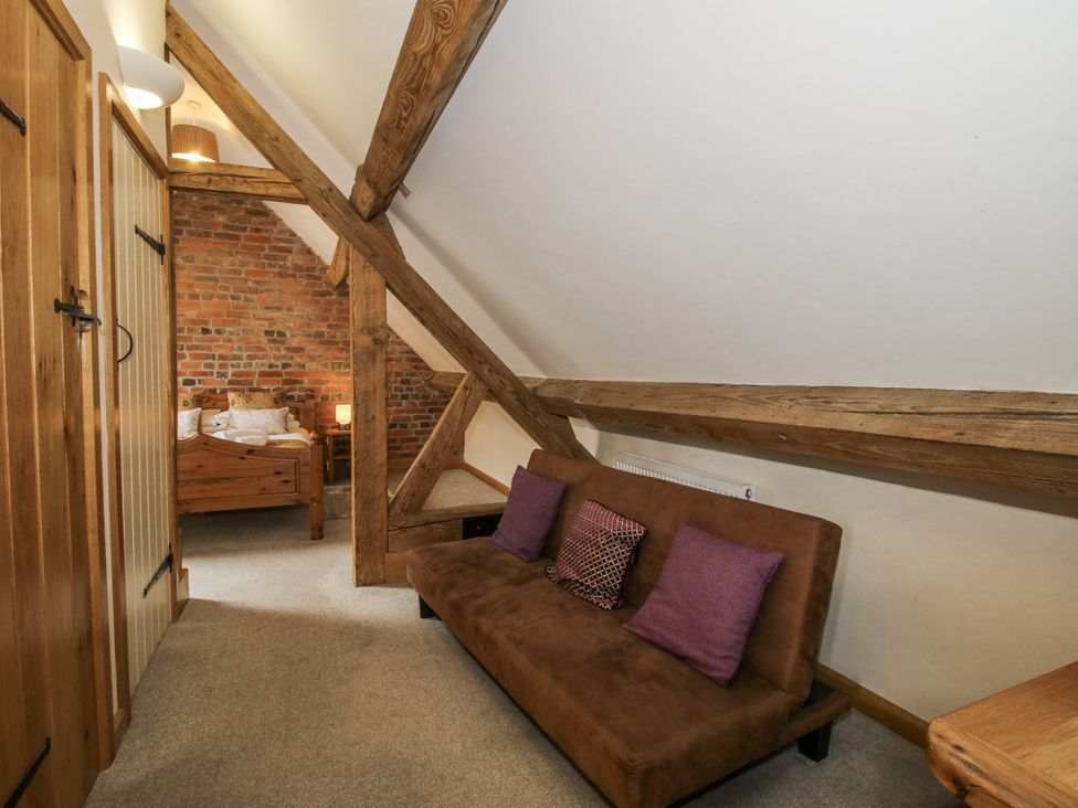 A bedroom with a sofa and bed at The Milking Parlour in Westhope