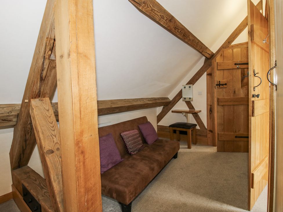 An attic with a sofa and wooden features at The Milking Parlour in Westhope
