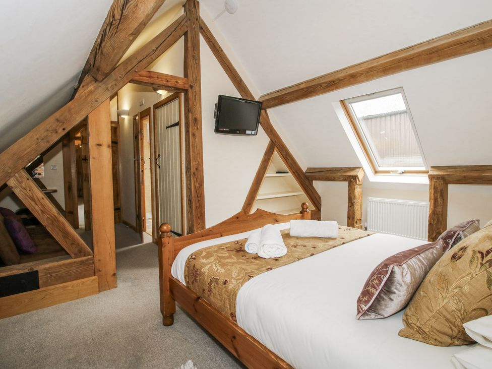 A bedroom with a bed, towels, and a television at The Milking Parlour in Westhope
