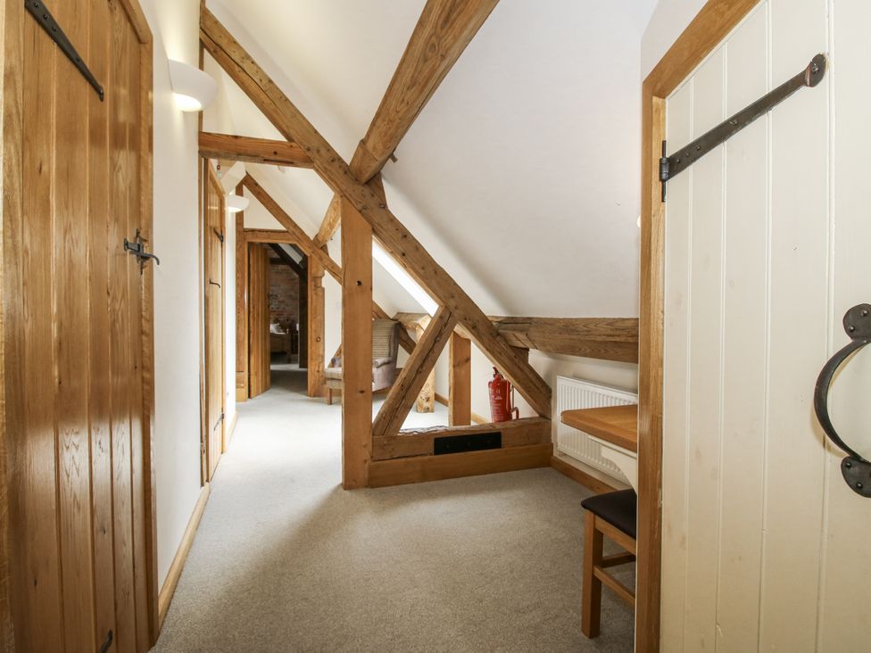 A hallway with wooden doors and beams at The Milking Parlour in Westhope