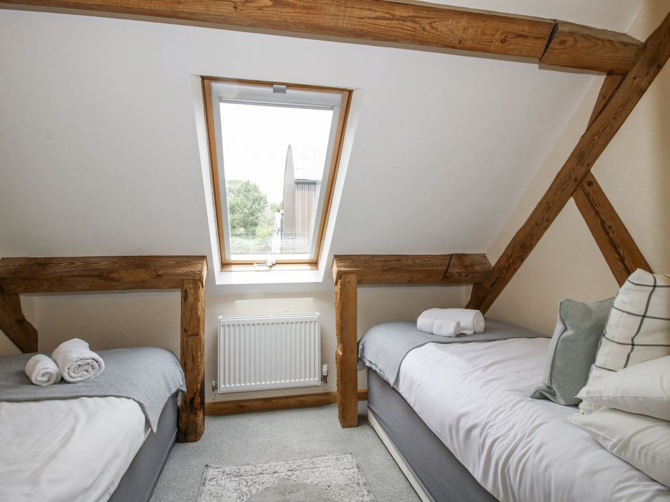 A bedroom with two beds and a window at The Milking Parlour in Westhope
