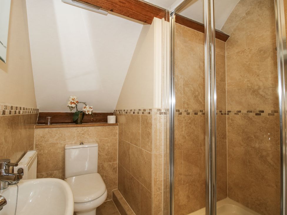 A bathroom with a shower, toilet, and sink at The Milking Parlour in Westhope