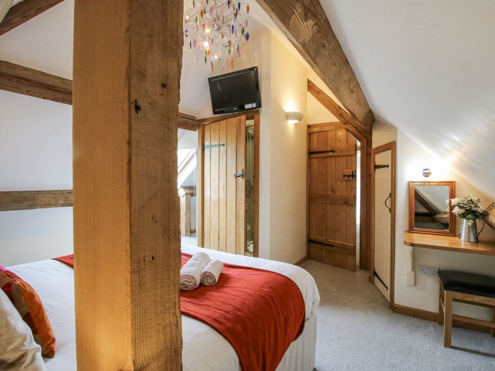 A bedroom with a bed and wooden door at The Milking Parlour in Westhope