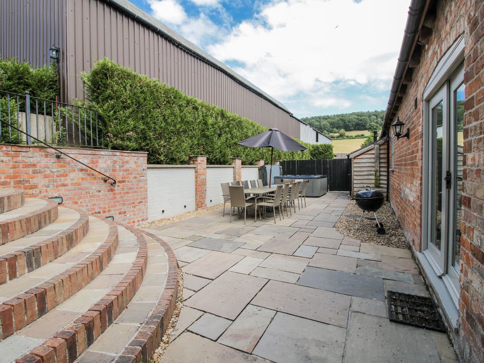 A patio area with steps, dining table, and chairs at The Milking Parlour in Westhope