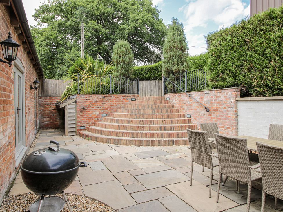 An outdoor area with a grill and dining table at The Milking Parlour in Westhope