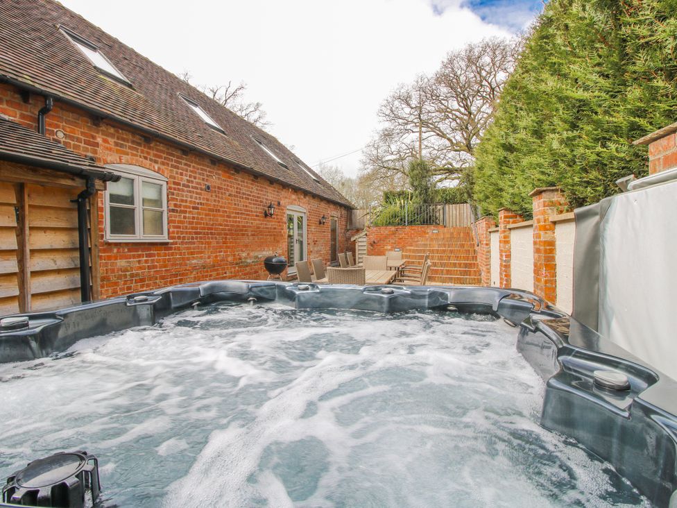 An outdoor area with a hot tub and seating arrangement at The Milking Parlour in Westhope