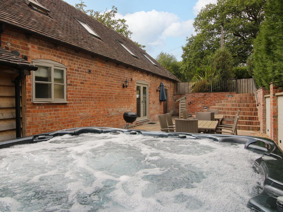 An outdoor area with a hot tub and seating at The Milking Parlour in Westhope
