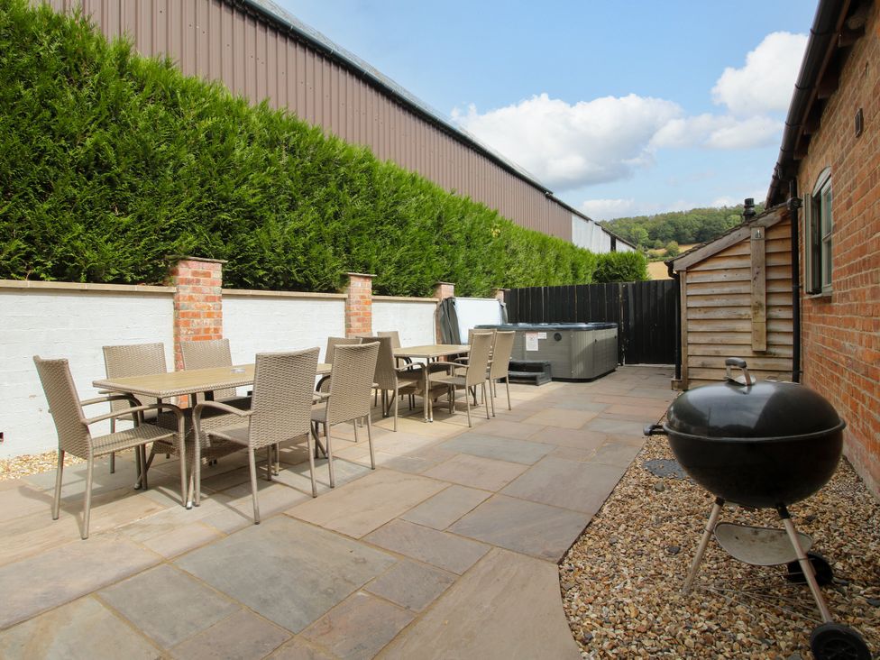 A garden with a dining set and hot tub at The Milking Parlour in Westhope