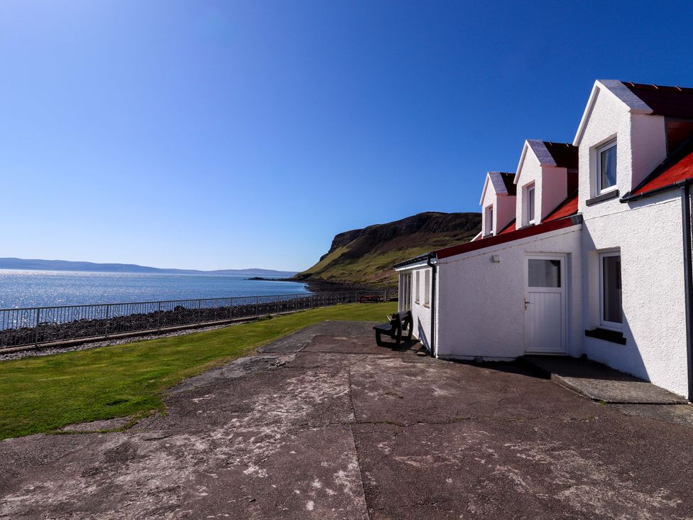 A house with a door and windows by the ocean at Jubilee Cottage in Uig
