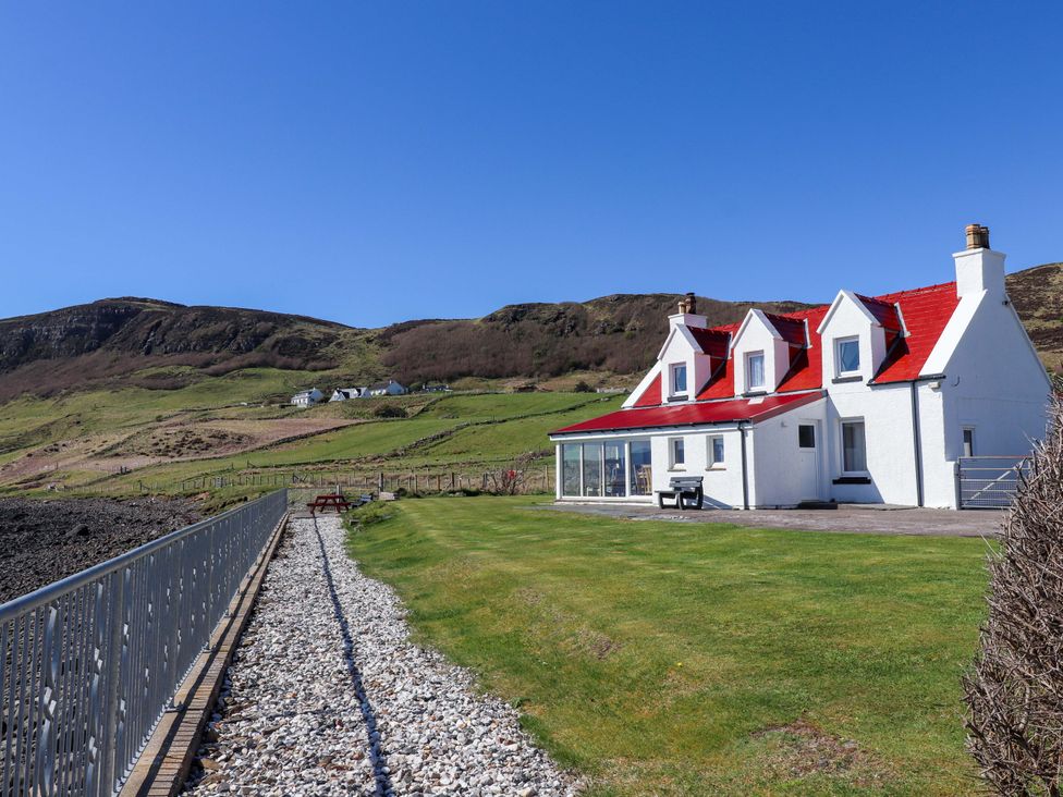 A house with a red roof and a garden at Jubilee Cottage in Uig
