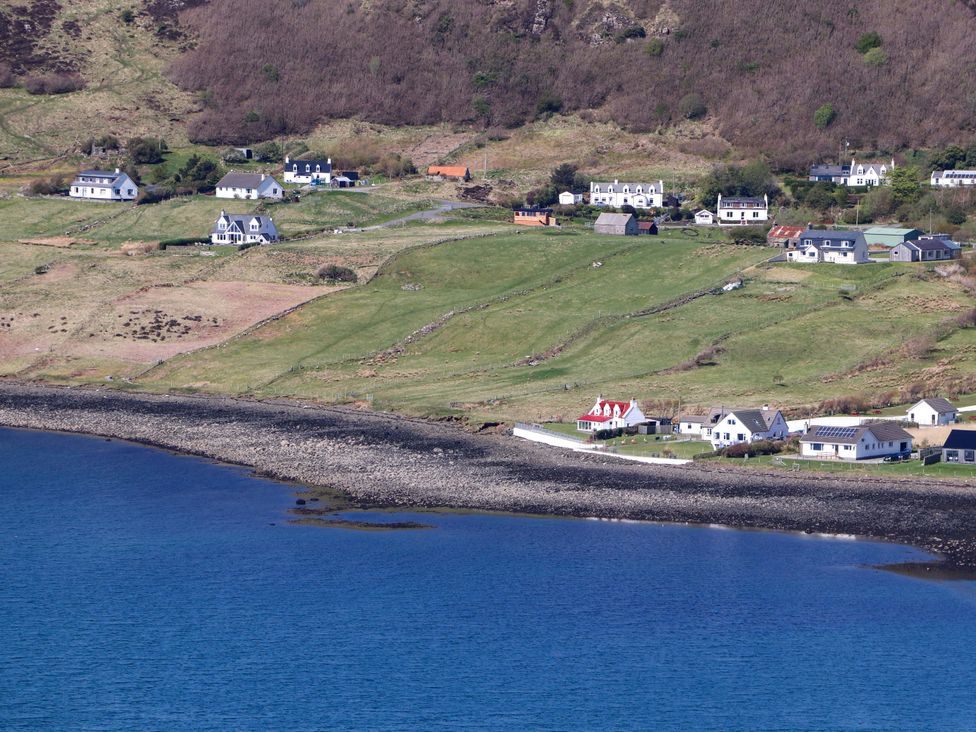 A landscape view featuring houses and grassland at Jubilee Cottage in Uig