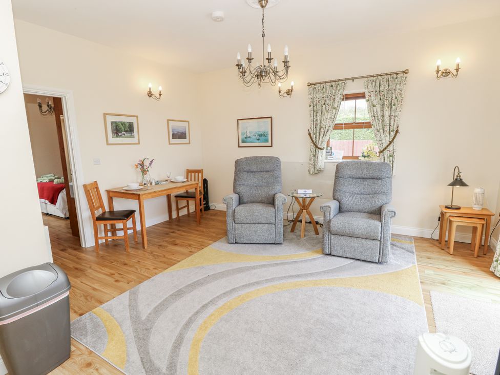 A living room with recliner chairs and a dining table at 2 The Stables in Ryde