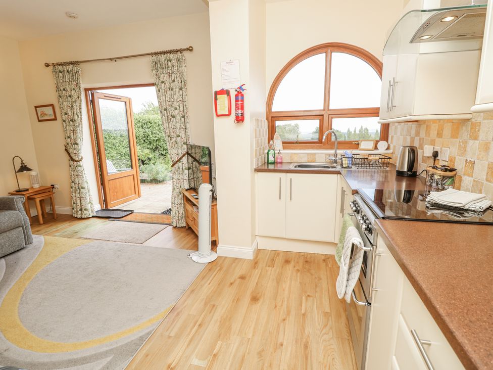 A kitchen with a stove and sink at 2 The Stables Ryde