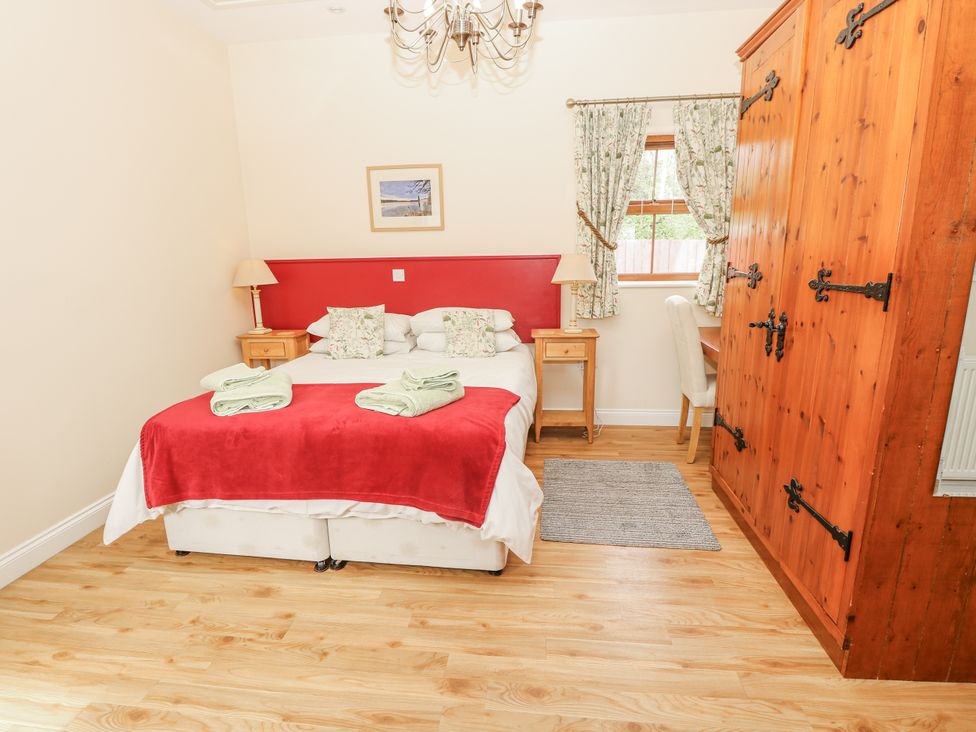 A bedroom with a bed and wardrobe at 2 The Stables Ryde