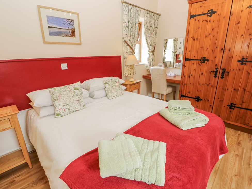 A bedroom with a bed and wardrobe at 2 The Stables in Ryde