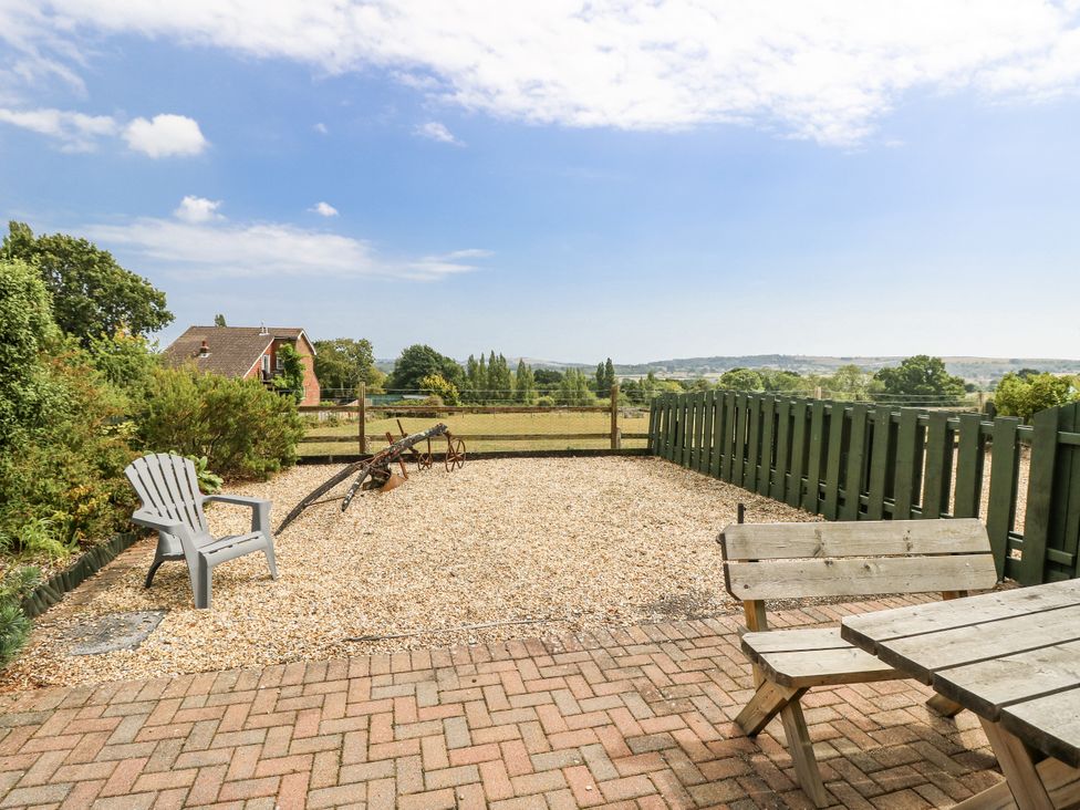An outdoor space with gravel, a chair, a table and a fence at 2 The Stables, Ryde