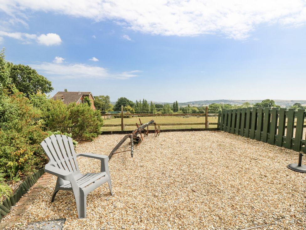 A garden area with a chair and gravel at 2 The Stables in Ryde