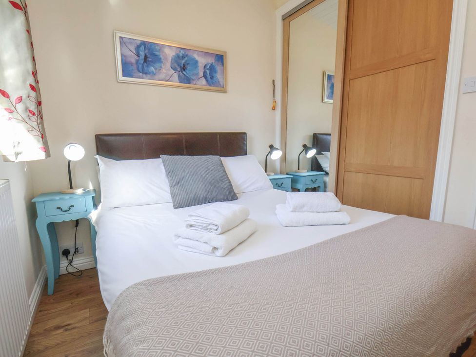 A bedroom with a bed and bedside tables at Primrose Lodge Saltburn-by-the-Sea