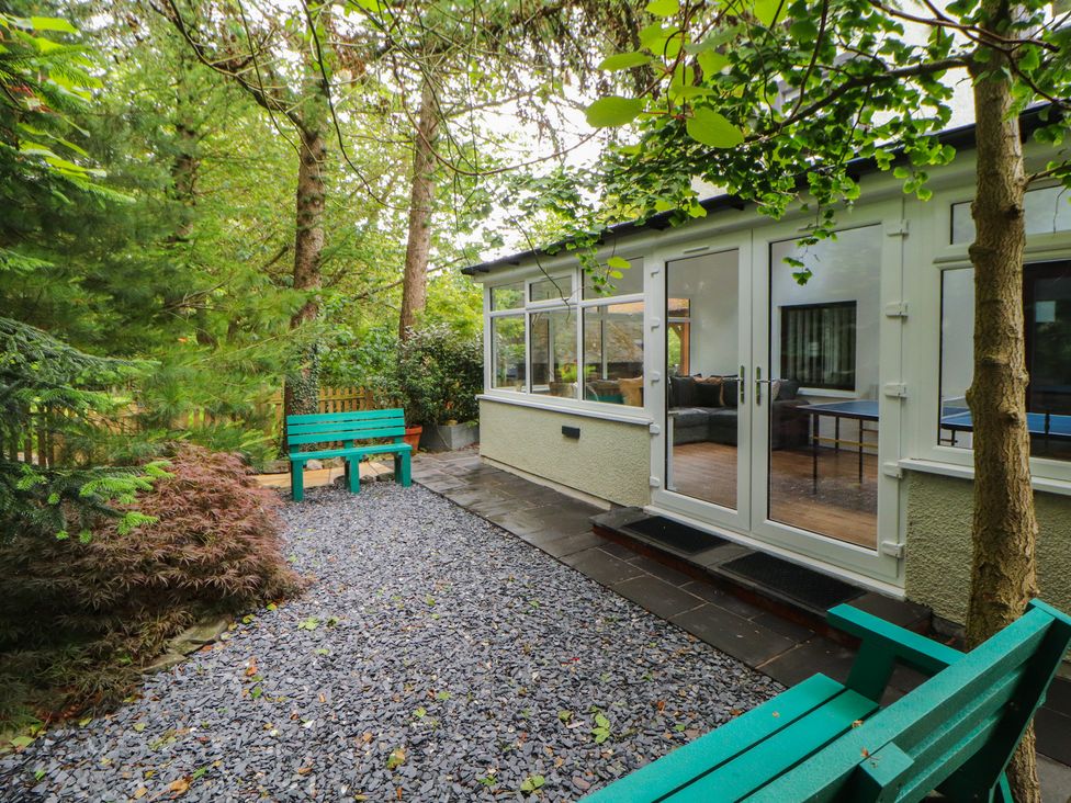 A garden with a green bench and gravel pathway at Eden House in Bardsea