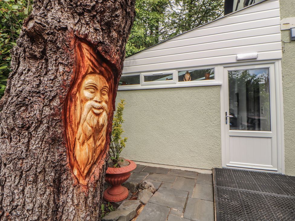 A tree with a carving and a door at Eden House Bardsea