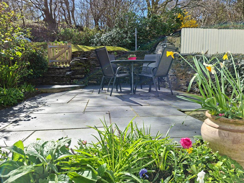 A garden with a table and chairs at Llannor in Borth-y-Gest