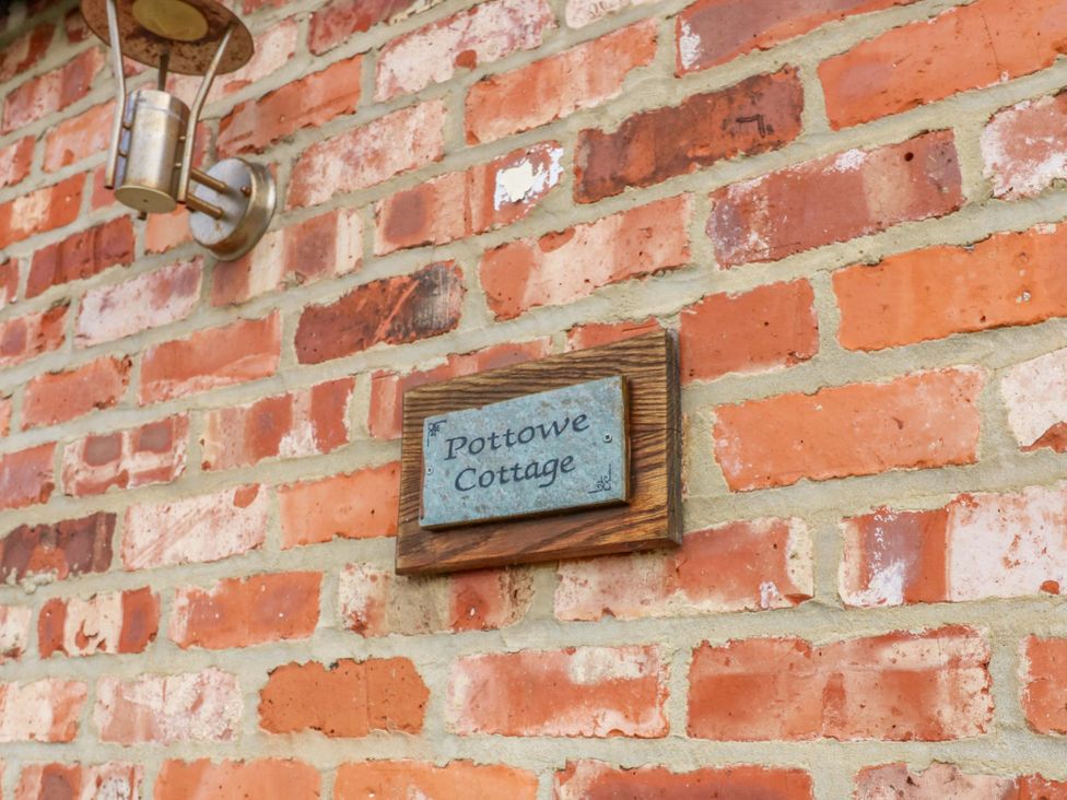 A sign with the name Pottowe Cottage on a brick wall at Pottowe Cottage near Stokesley