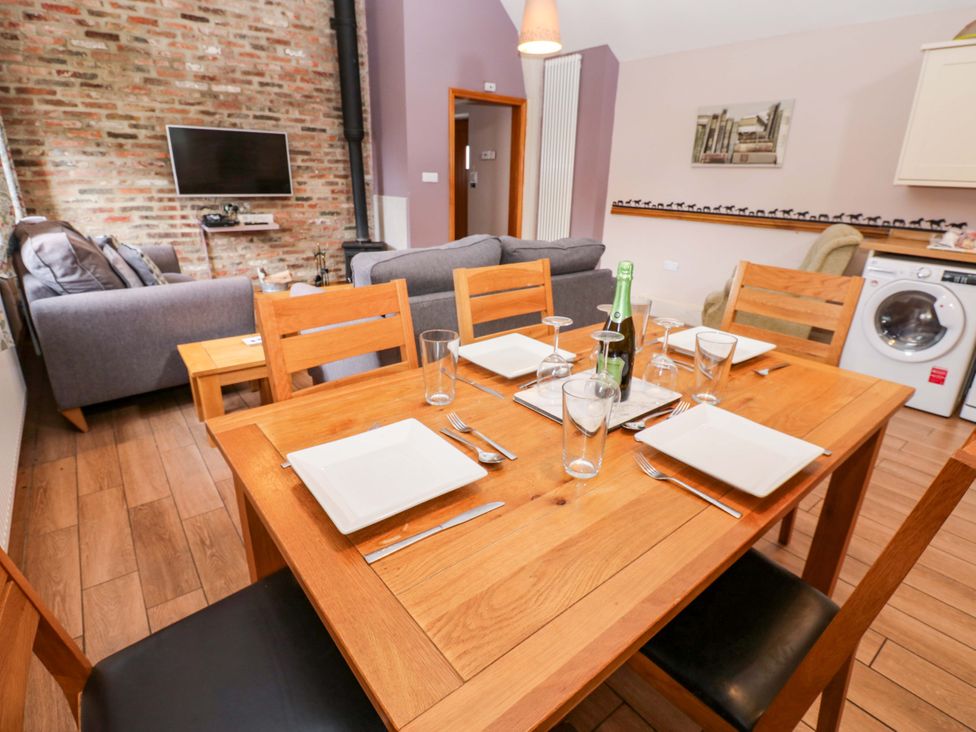 A dining room with a table set for meals at Pottowe Cottage in Potto near Stokesley